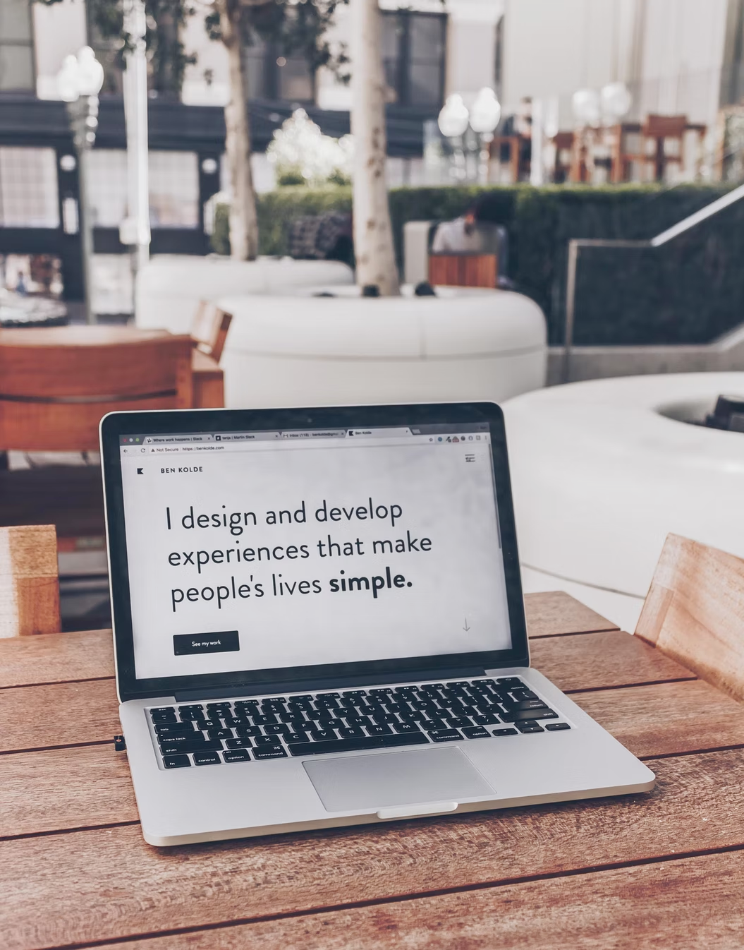 a laptop open with the words 'I design and develop experiences that make people's lives simple.'